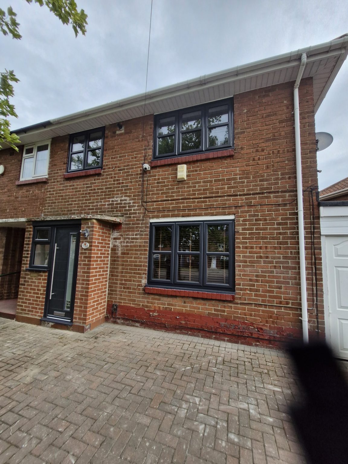 A brick semi-detached house with new anthracite grey windows and front door
